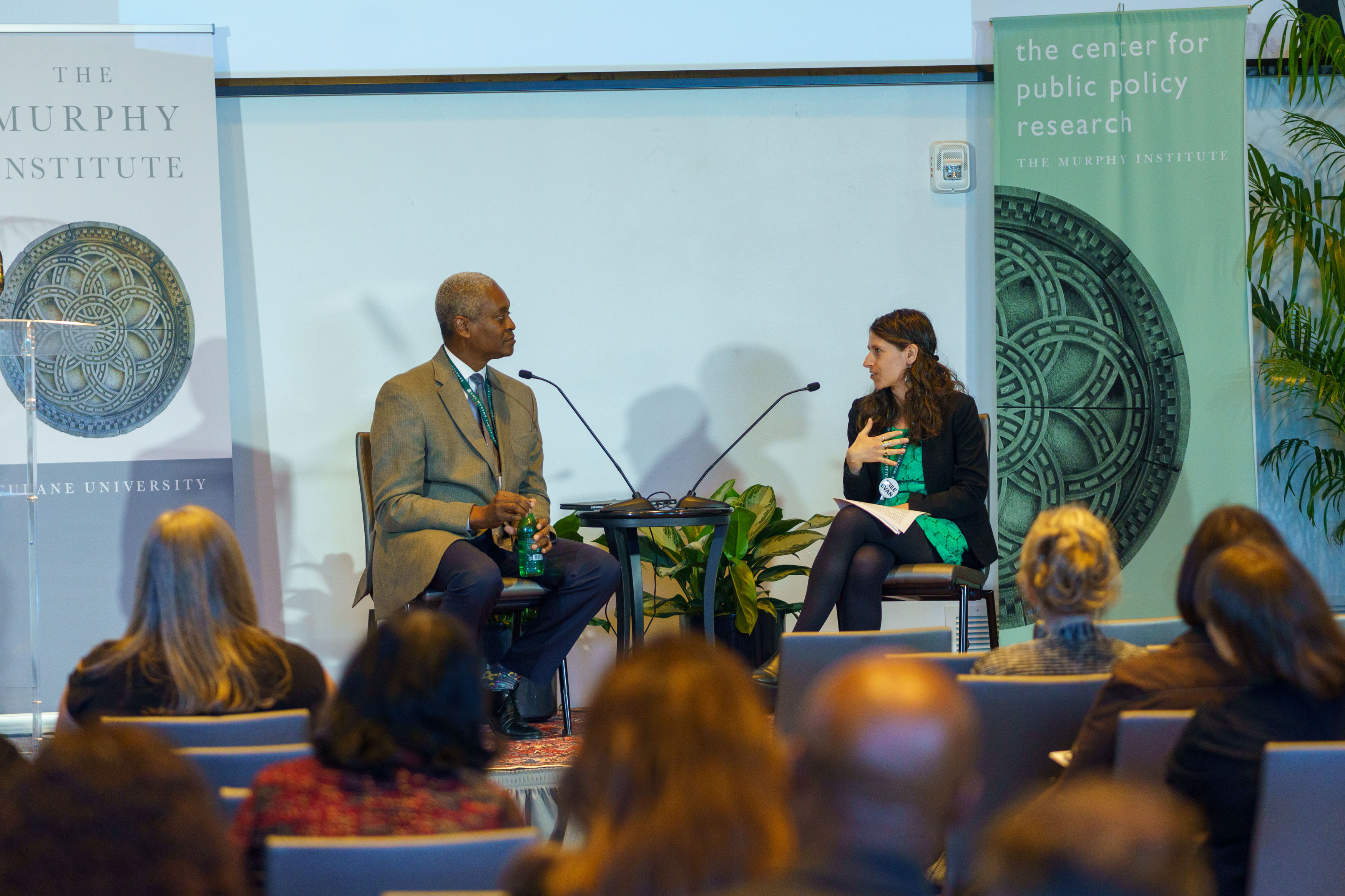 Two people on stage with audience in foreground.
