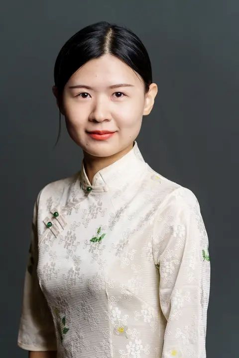Yu Liu, a woman in traditional Chinese dress smiles gently.