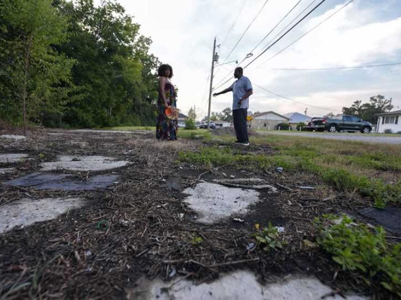 A man and a woman alongside the IMTT facility in St. Rose, LA