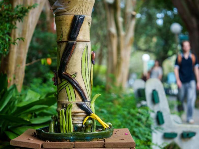Student walking past a sculpture in front of the Caroline Richardson Building
