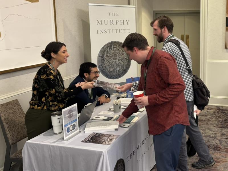 Murphy Institute staff at a table with a banner and brochures
