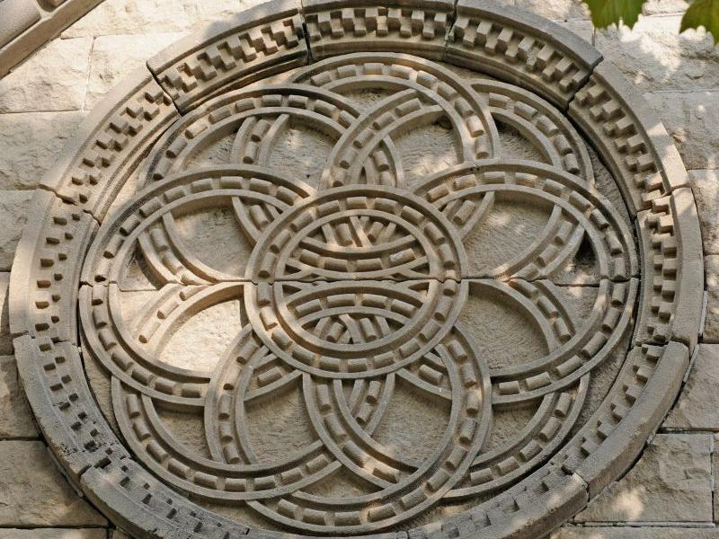 Stone carving of a circular, geometric pattern with interlocking rings.