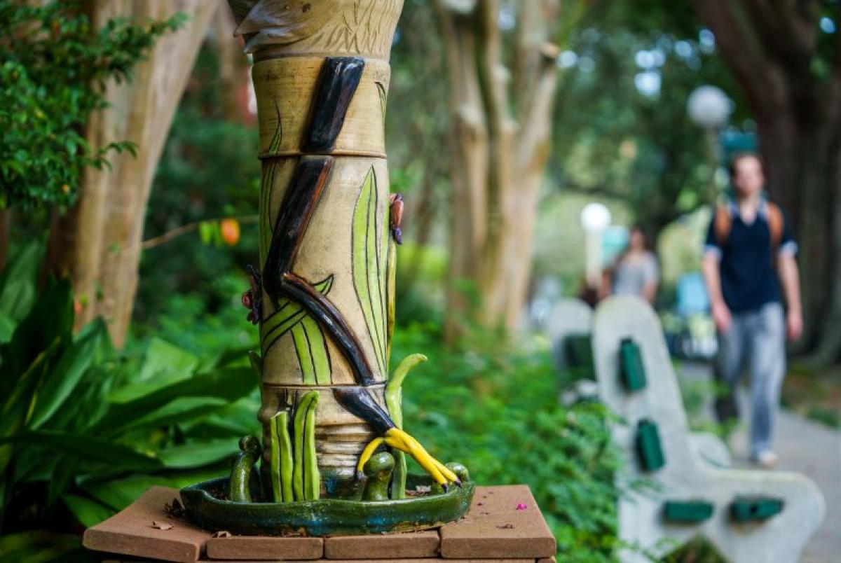 Student walking past a sculpture in front of the Caroline Richardson Building