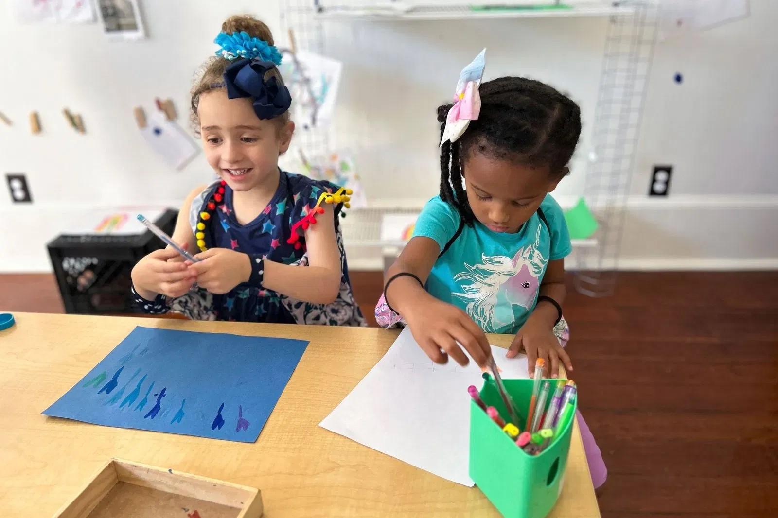 two preschool girls drawing pictures