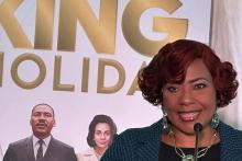 Bernice King speaks in front of a portrait of her parents