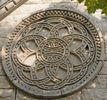 Stone carving of a circular, geometric pattern with interlocking rings.