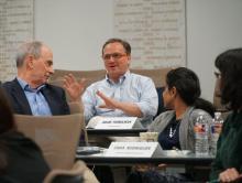 Three people in discussion around a table.