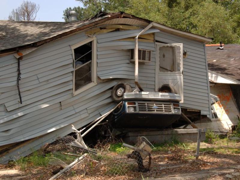 Flood-damaged house on top of car